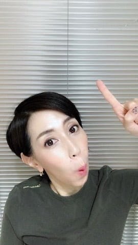 上を指すポーズ